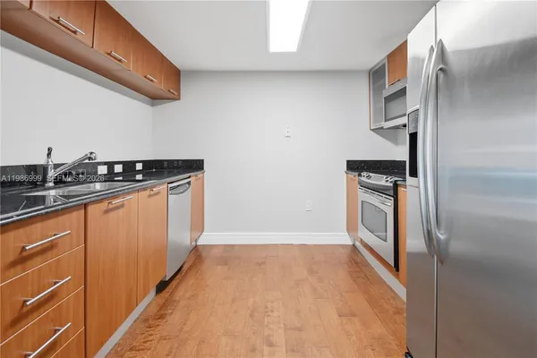 a kitchen with granite countertop a stove and a refrigerator