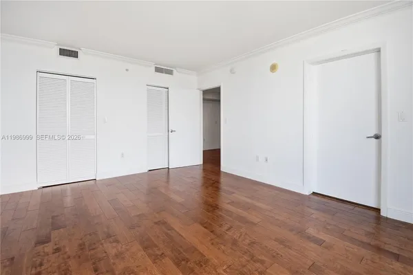 a view of an empty room with wooden floor