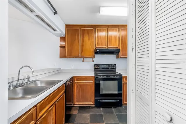 a kitchen with stainless steel appliances a sink stove and cabinets