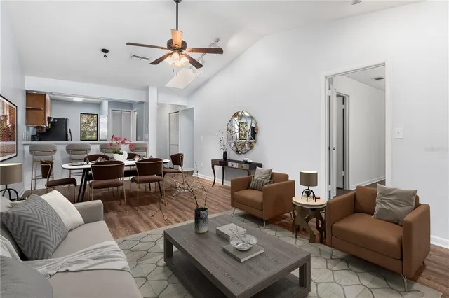 a view of an empty room with wooden floor and a ceiling fan