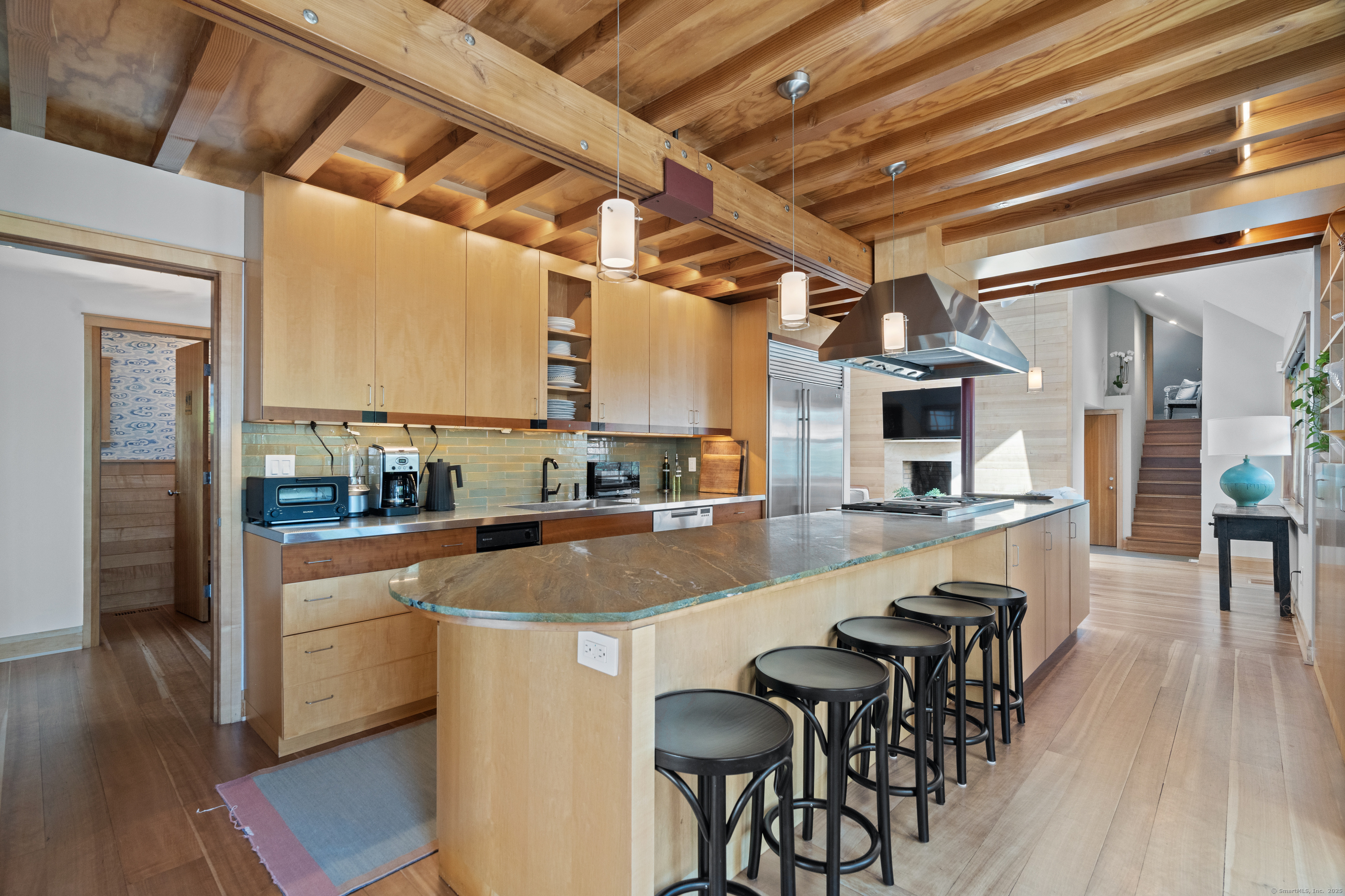 33 Seaview Avenue Madison, CT 06443 - Photo 11 of 40 a kitchen with stainless steel appliances kitchen island granite countertop a table chairs in it and wooden floors