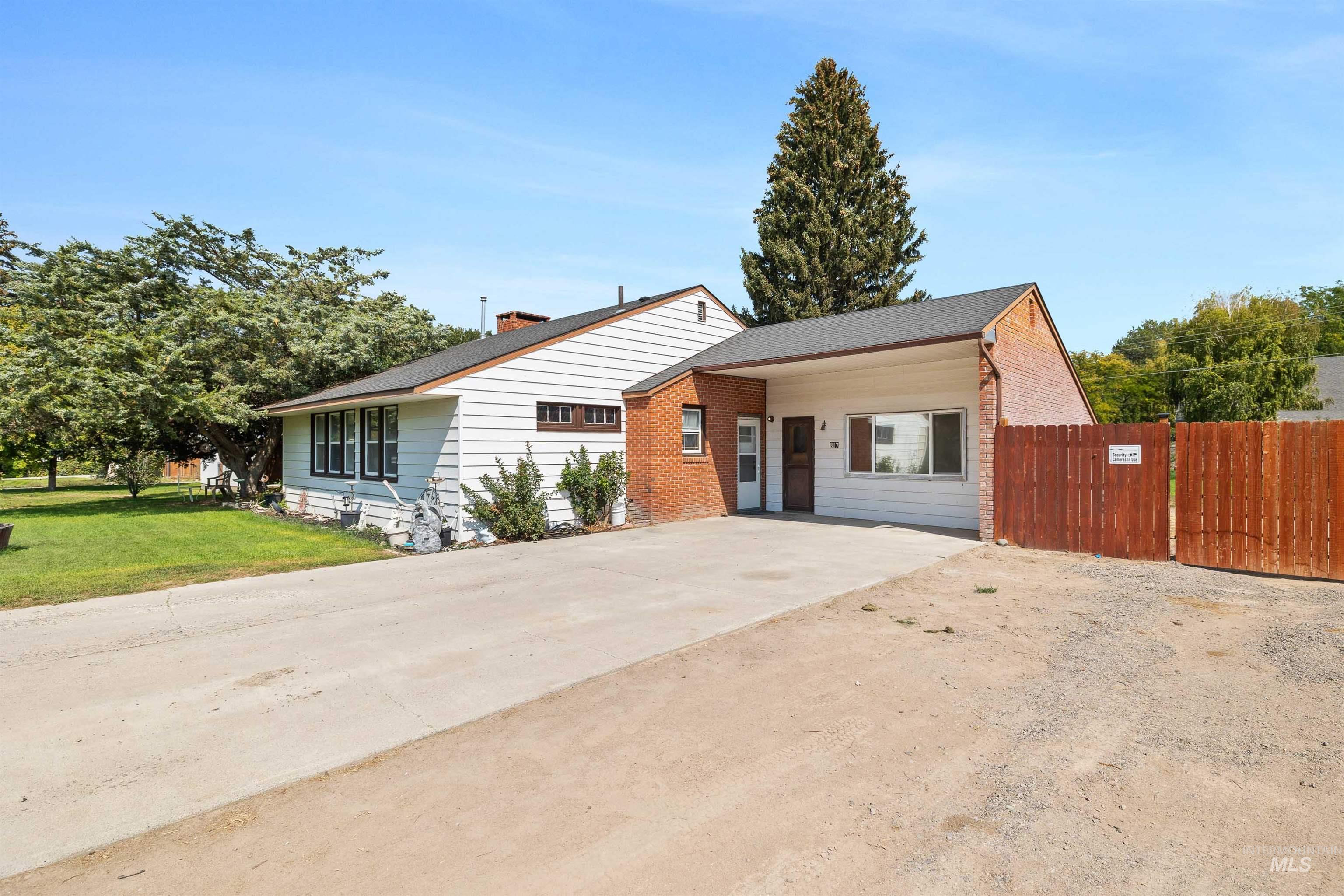 817 Union Avenue Filer, ID 83328 - Photo 30 of 37 View of front of house with driveway, brick siding, a chimney, and a shingled roof