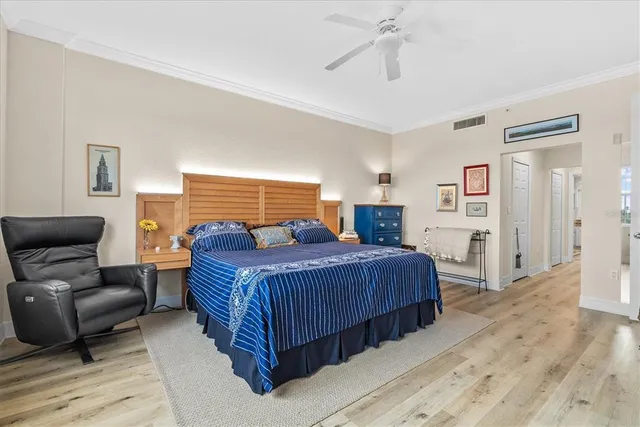 a bedroom with a large bed a chandelier and a couch