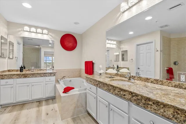 a bathroom with a granite countertop sink a large mirror and shower