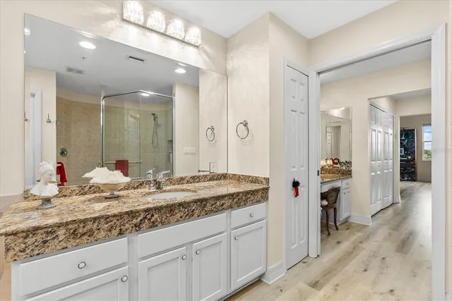 a en suite bathroom with a granite countertop sink and a mirror