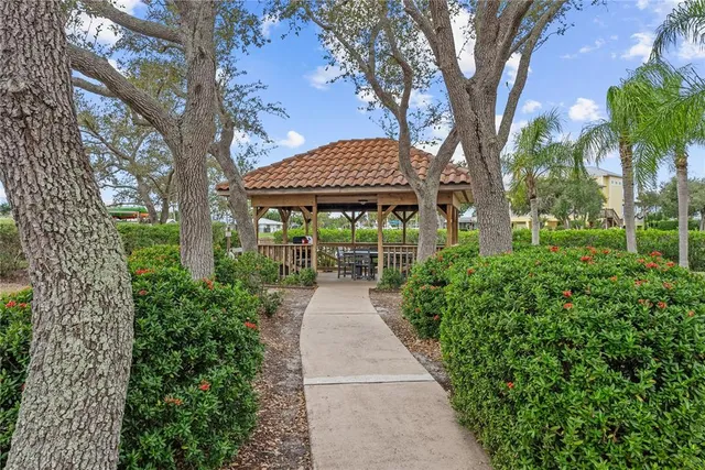a view of a pathway with a tree in the garden