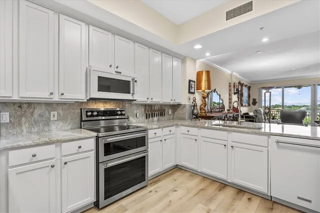 a kitchen with appliances a sink and cabinets