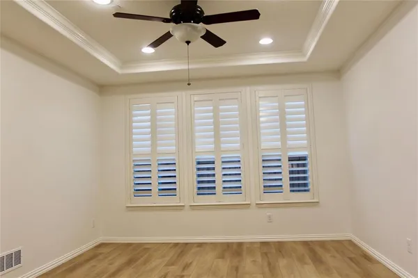 en empty room with windows and ceiling fan