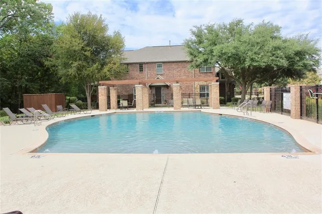 a view of a house with pool lawn chairs and a yard