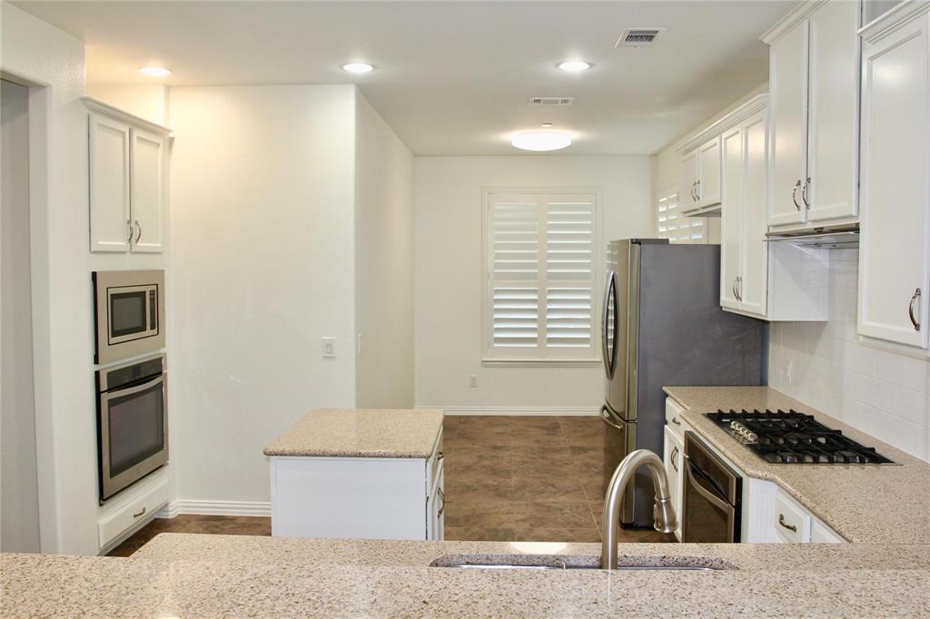 4821 Bayview Drive Plano, TX 75093 - Photo 5 of 21 a kitchen with stainless steel appliances granite countertop a stove and a refrigerator