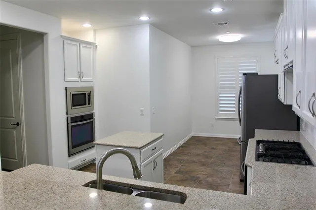 a kitchen with stainless steel appliances granite countertop a refrigerator and a stove