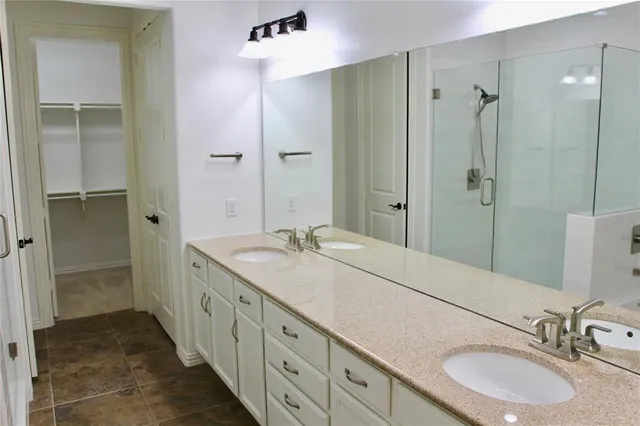 a bathroom with a double vanity sink mirror double and shower