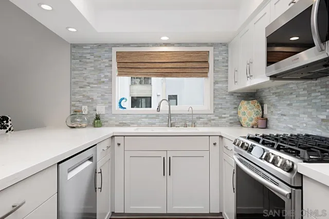 a kitchen with granite countertop a sink stove and cabinets
