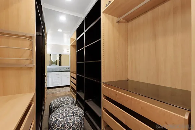 a view of walk in closet with wooden floor