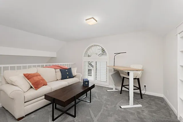 a living room with furniture a rug and a window