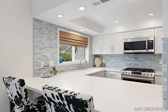 a kitchen with granite countertop a stove and a microwave