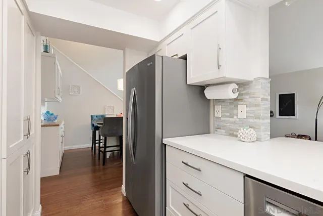 a kitchen with stainless steel appliances kitchen island a refrigerator sink and cabinets