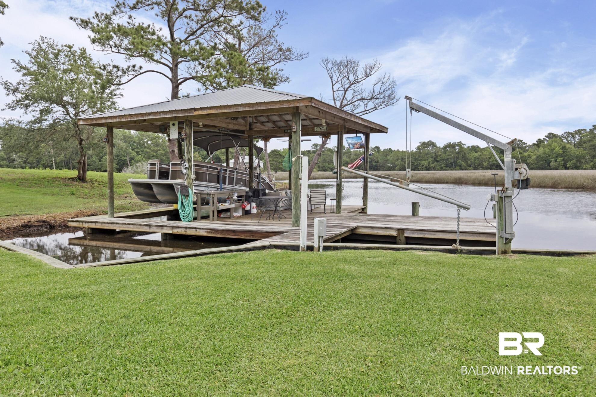 12171 Marguerite Drive Coden, AL 36523 - Photo 23 of 44 Covered boat dock featuring a metal roof and durable wood construction