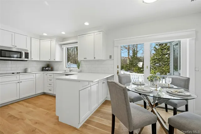 a kitchen with stainless steel appliances granite countertop a stove a sink a microwave a dining table and chairs