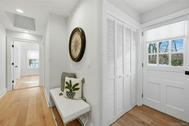 a view of a hallway with entryway wooden floor and front door