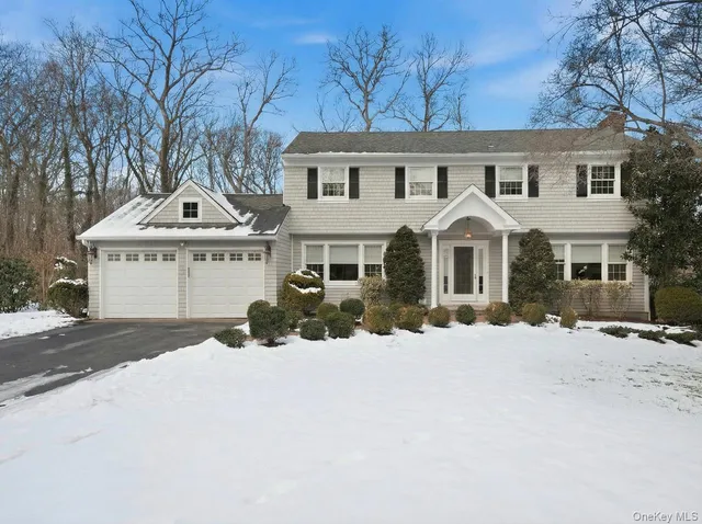 a front view of a house with a yard covered in snow