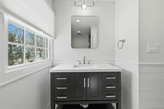 a bathroom with a granite countertop sink a mirror and a window