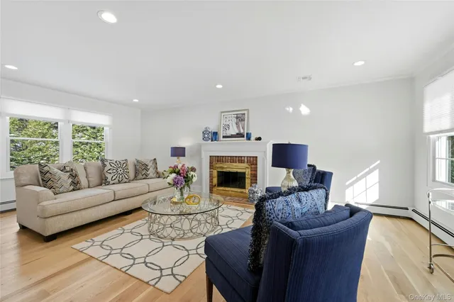 a living room with furniture a fireplace and a large window