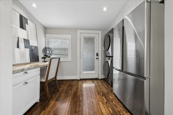 a view of a kitchen with refrigerator and wooden floor