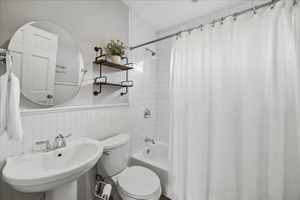 a bathroom with a sink a toilet and a mirror