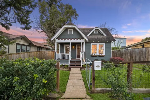 a front view of a house with a yard and potted plants