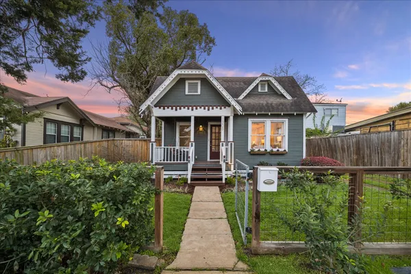 a front view of a house with a yard and potted plants