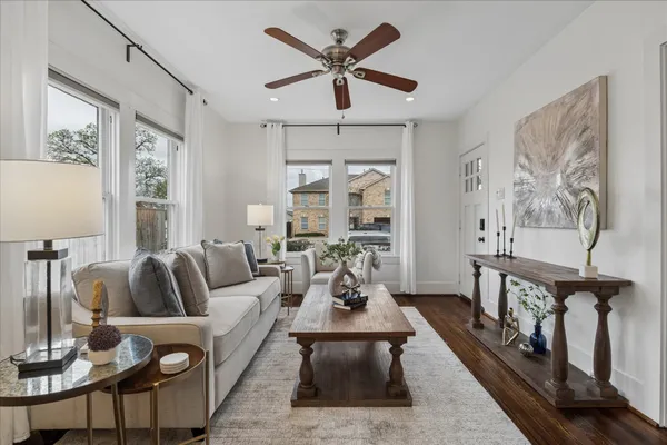 a living room with furniture a large window and a chandelier