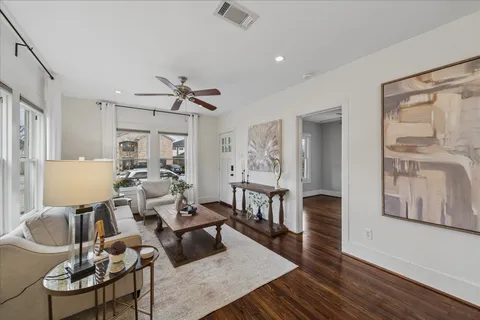 a living room with furniture a table and wooden floor