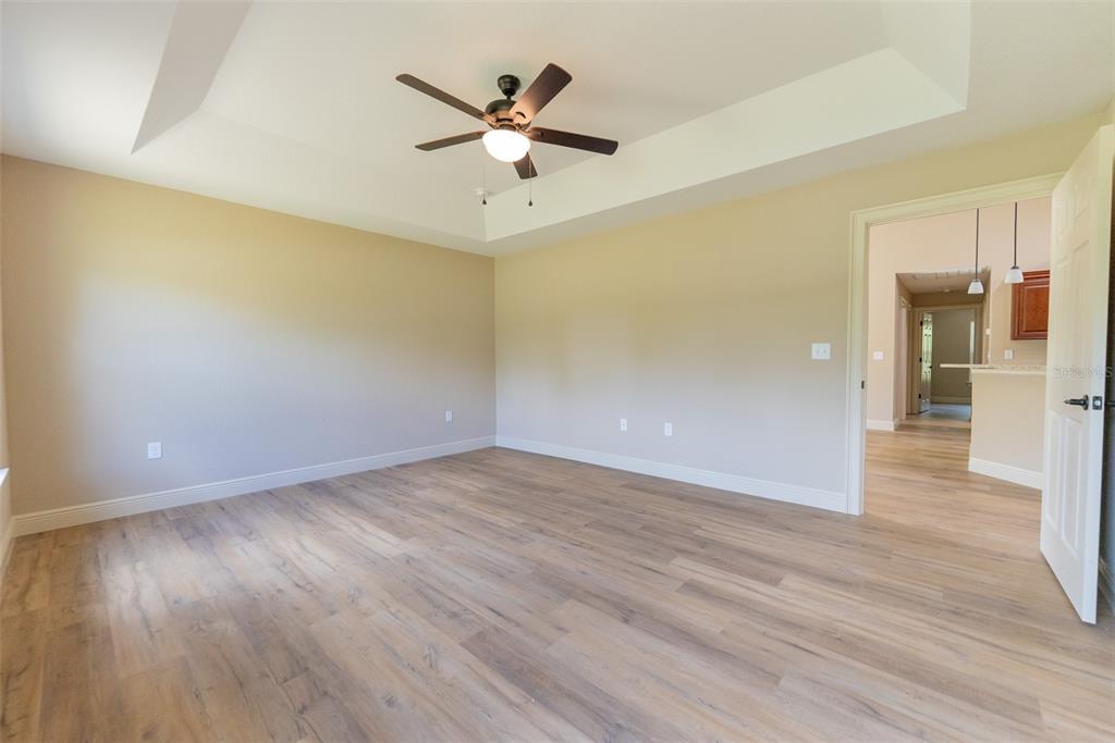 23393 Southwest Pony Ridge Drive Dunnellon, FL 34431 - Photo 31 of 64 an empty room with wooden floor and a ceiling fan