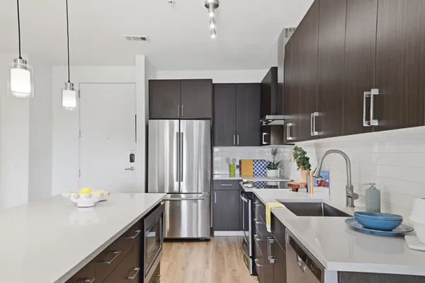 a kitchen with stainless steel appliances a sink and a refrigerator