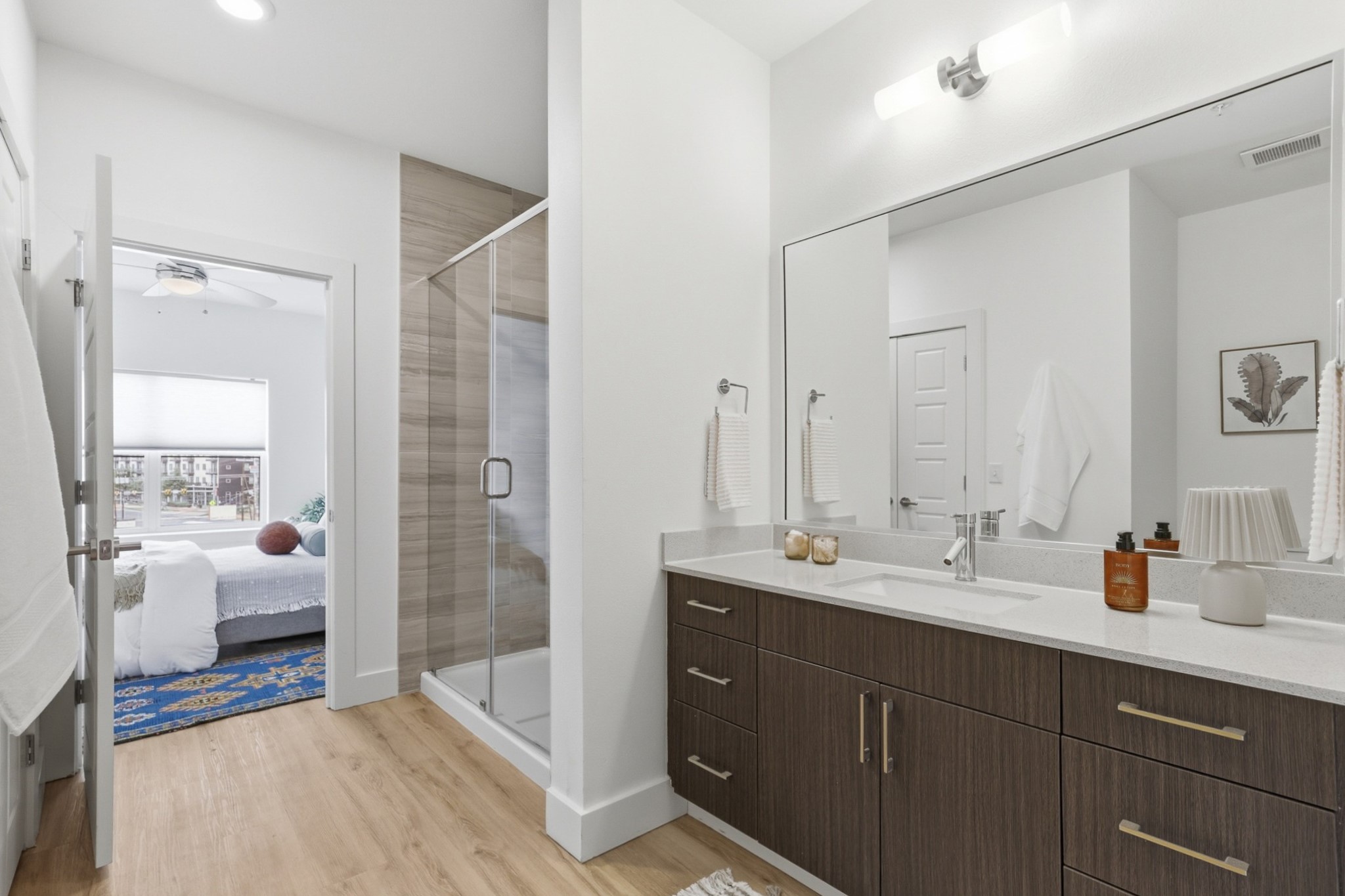 6444 Burnet Road, Unit 403 Austin, TX 78757 - Photo 12 of 29 a en suite bathroom with a double vanity sink a large mirror and shower