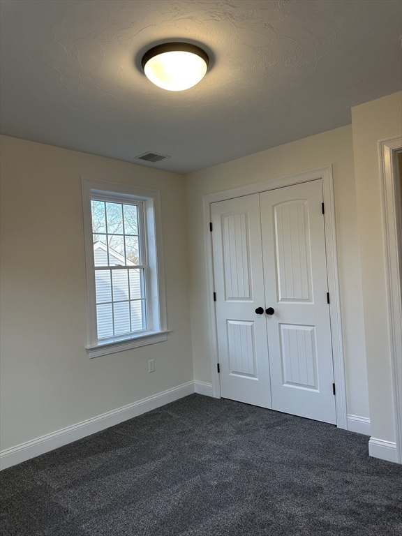 2 Hummingbird Path Watertown, MA 02472 - Photo 23 of 28 an empty room with wooden floor and windows