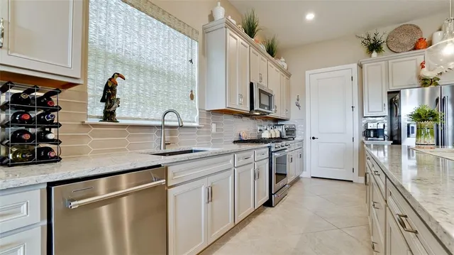 a kitchen with stainless steel appliances a stove a sink and a refrigerator
