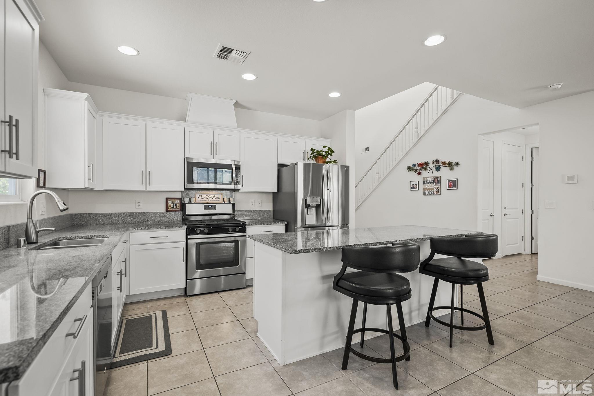 2835 Bonfire Lane Reno, NV 89521 - Photo 6 of 28 a kitchen with stainless steel appliances granite countertop a refrigerator and a stove top oven with white cabinets