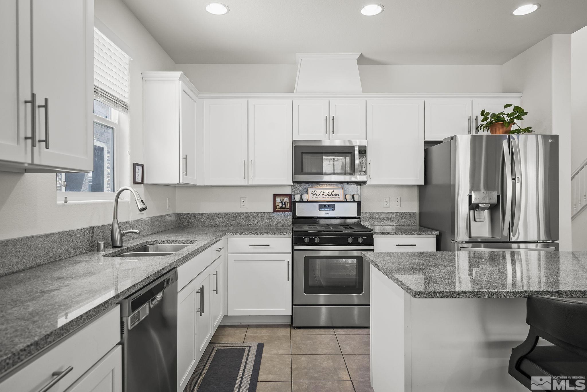 2835 Bonfire Lane Reno, NV 89521 - Photo 7 of 28 a kitchen with kitchen island granite countertop a sink stove and refrigerator