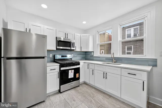 a kitchen with granite countertop a refrigerator stove and microwave