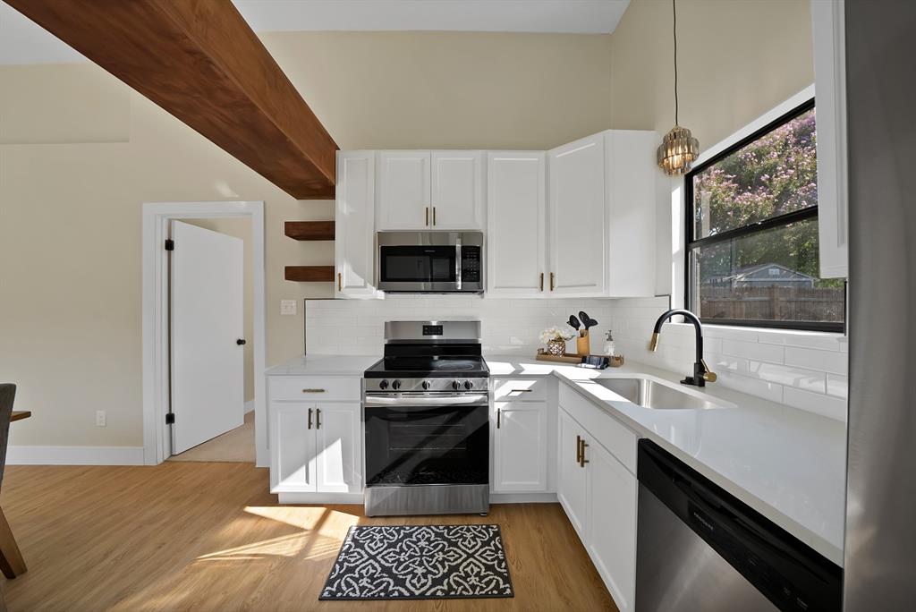 a kitchen with a sink appliances and cabinets