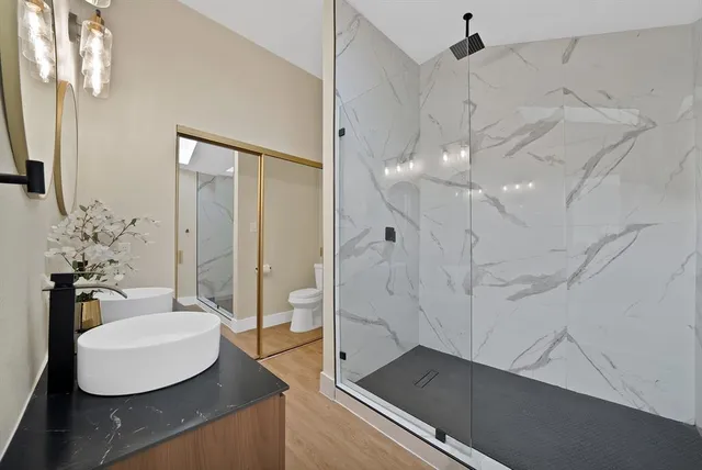 a bathroom with a sink shower and a mirror