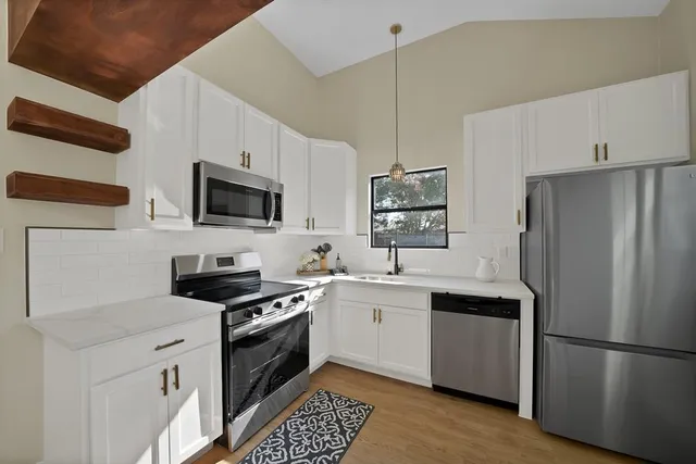 a kitchen with stainless steel appliances a refrigerator sink and microwave
