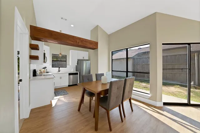 a dining room with furniture and a floor to ceiling window