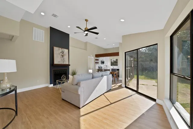 a living room with furniture a floor to ceiling window and a flat screen tv