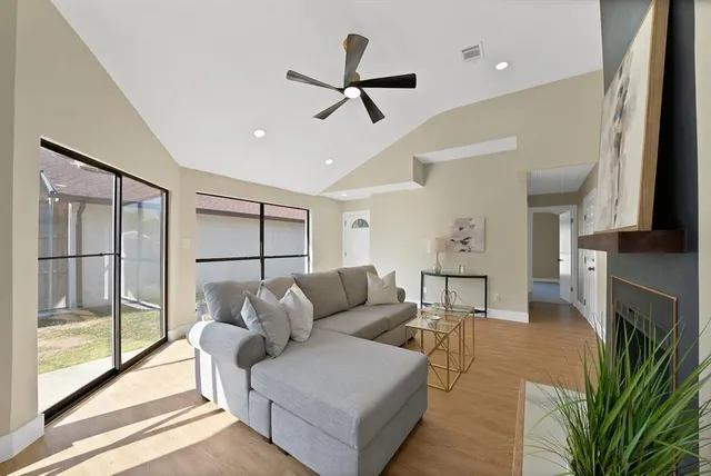 a living room with furniture a ceiling fan and a fireplace
