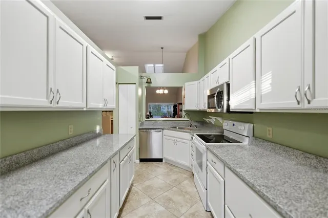 a kitchen with stainless steel appliances granite countertop a sink and dishwasher a stove top oven with wooden floor