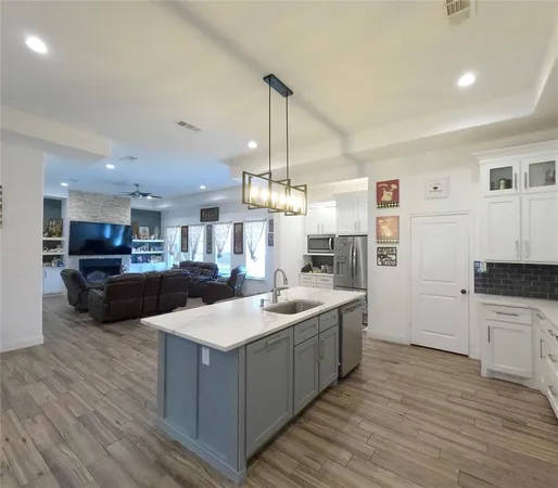 a kitchen with stainless steel appliances granite countertop a sink and a wooden floors