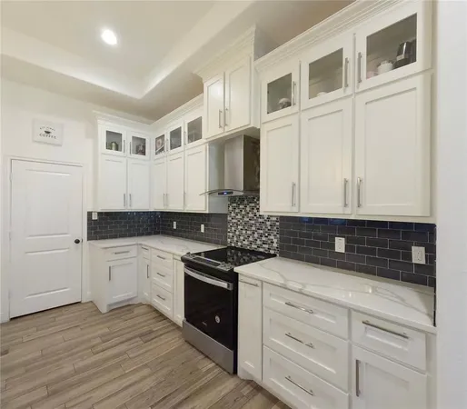 a kitchen with stainless steel appliances granite countertop a stove and a white cabinets